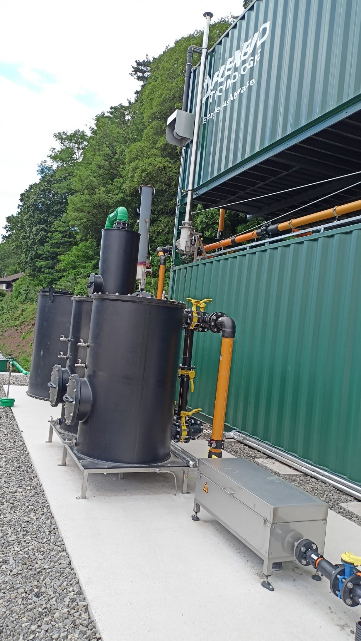 Anlagentechnik mit Tanks, Rohrleitungen und Containern im Außenbereich