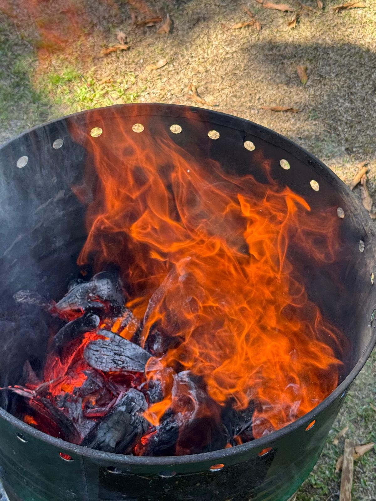 Flammen im Pyrolyse-Fass: aus Biomasseresten wird Pflanzenkohle